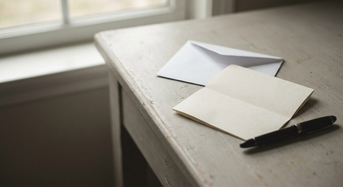 Une lettre pliée et son enveloppe ouverte sur un bureau